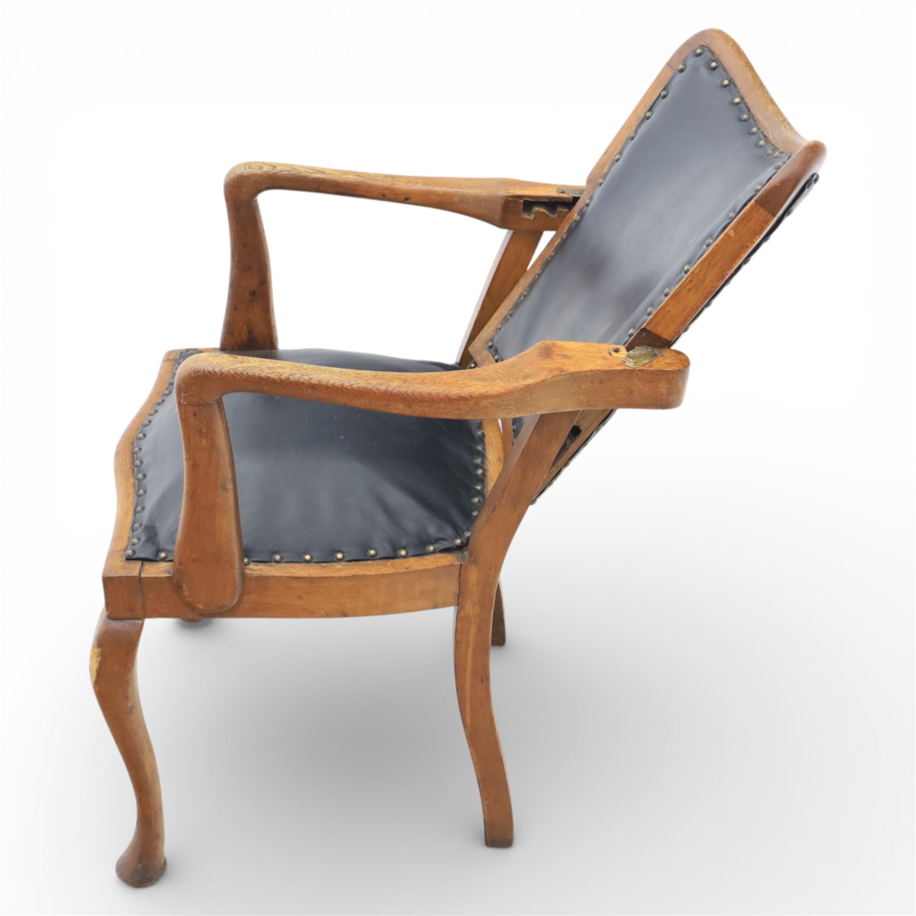 20th century oak recliner armchair, the curved back upholstered in leather with brass stud edging, hinged reclining back operated by side ratchet fittings, leather upholstered seat, shaped open arms, raised on cabriole legs