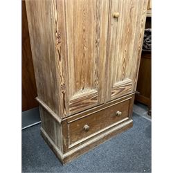 Victorian pitch pine double wardrobe, projecting moulded cornice over two panelled doors, the interior fitted with hanging rail and hooks, single drawer to base