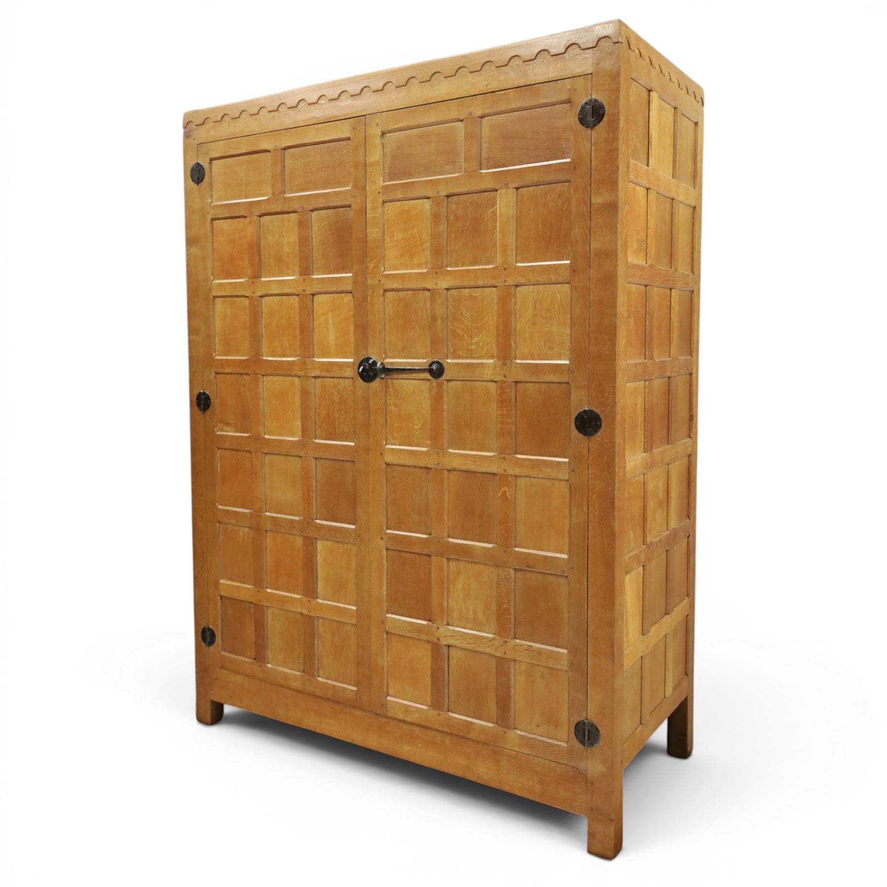 Mouseman - early-to-mid-20th century panelled and adzed double wardrobe, the arcade carved cresting rail over two panelled doors, with wrought metal hinges and latch, deep relief carved mouse signature, the interior fitted with hanging rail, by the workshop of Robert Thompson of Kilburn