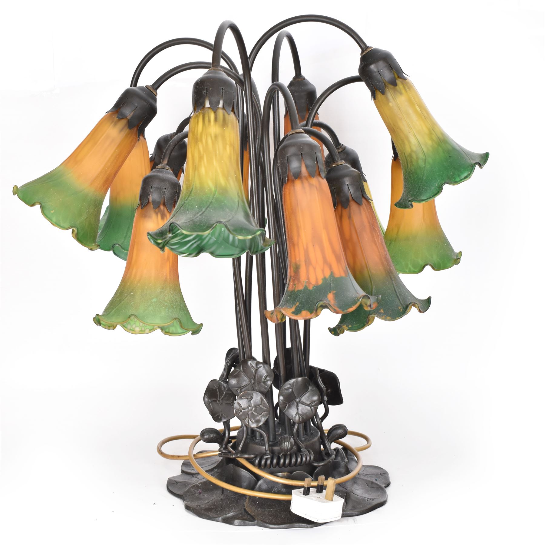 Art Nouveau Tiffany style table lamp, the bronzed base modelled as lily pads leading to tendrils and twelve branches supporting green and yellow glass lily flower shades, H53cm