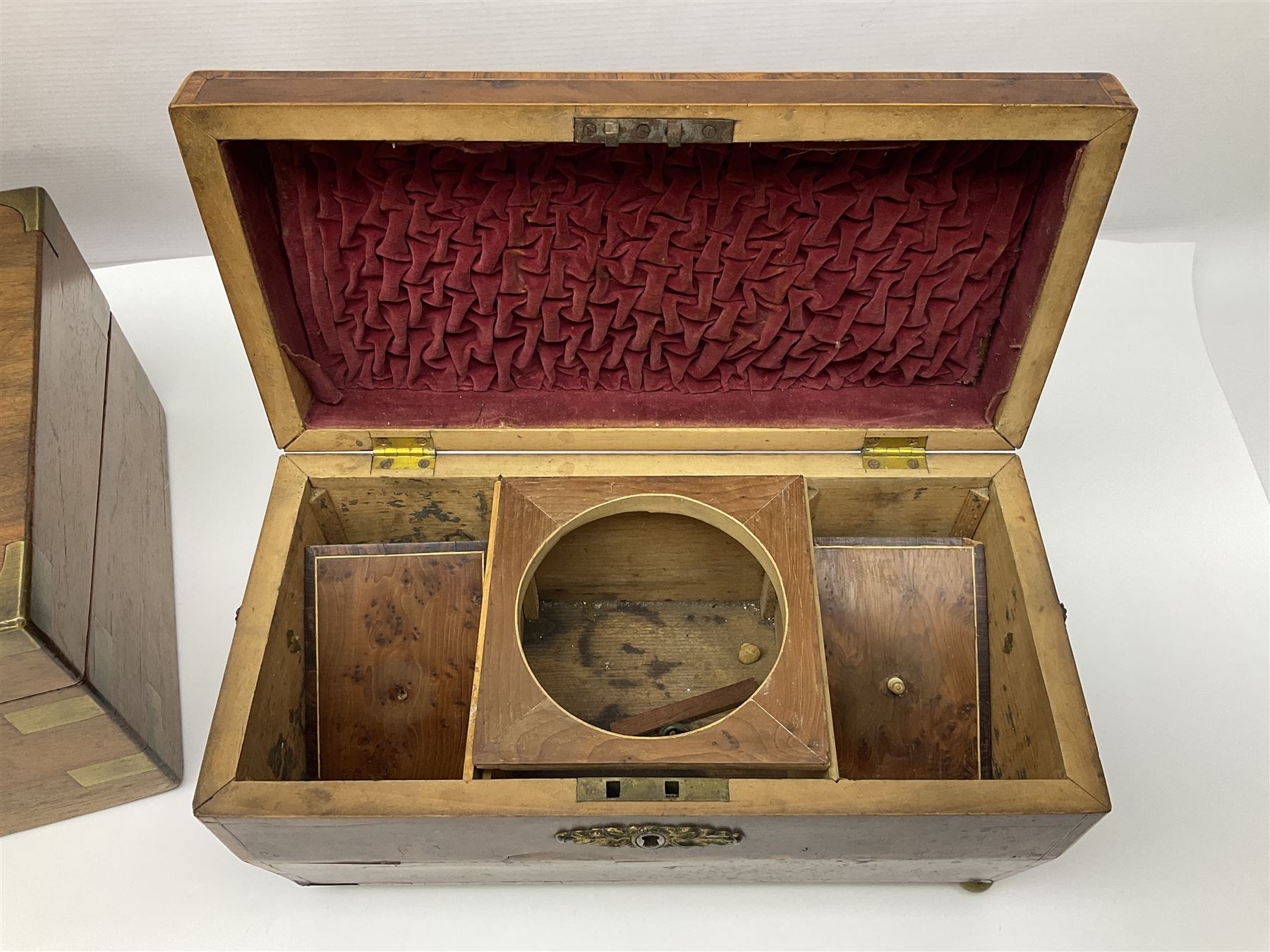 19th century burr yew wood tea caddy, of sarcophagus form, with strung details and brass mounts, the interior split into three compartments, upon four brass bun feet, together with an oak and brass bound writing slope, with red leather interior with gilt detailing, largest H16cm, W40cm