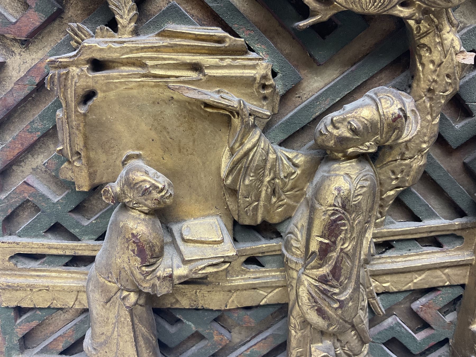 Two carved oriental wall hangings, the first example gilded depicting a temple and garden scene, the second figures in a garden, L49cm