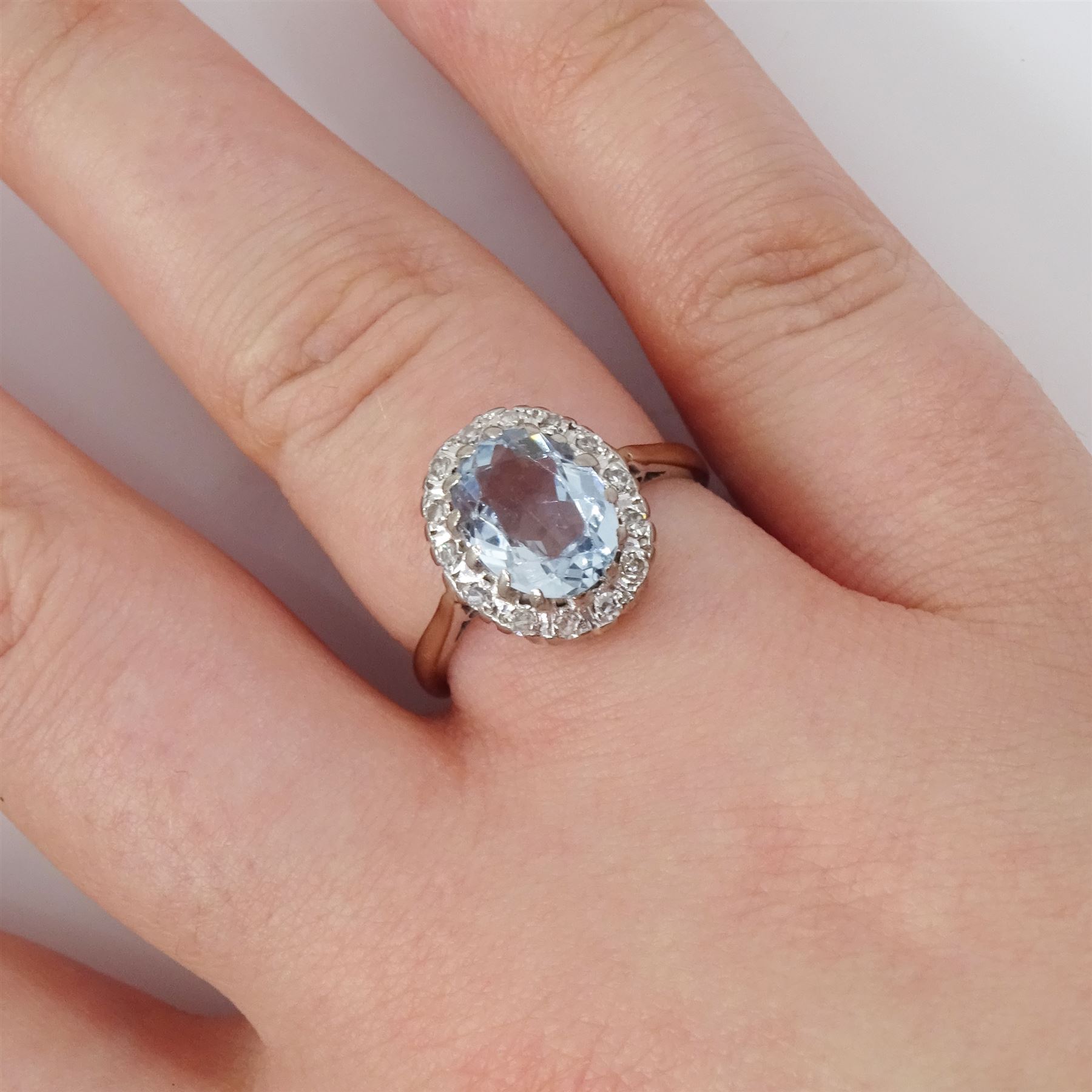 White gold aquamarine and diamond cluster ring, oval cut aquamarine of approx 1.35 carat, with single cut diamond surround, stamped 18ct