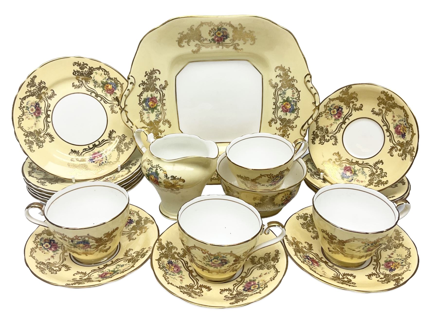 Aynsley tea service for six, decorated with floral sprays in ornate gilt detailing on cream ground, comprising six teacups and saucers, open sucrier and milk jug and cake plate, all with printed marks beneath