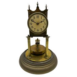 An anonymous early 20th century German 400-day torsion clock, with a circular enamel dial, upright Arabic numerals and minute track, spade hands under a glass shade, circular rotating pendulum with regulation, on a circular brass base with adjustable feet. 
H33cm
