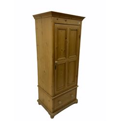 Waxed pine narrow wardrobe/cupboard, fitted with single panelled door, above single drawer