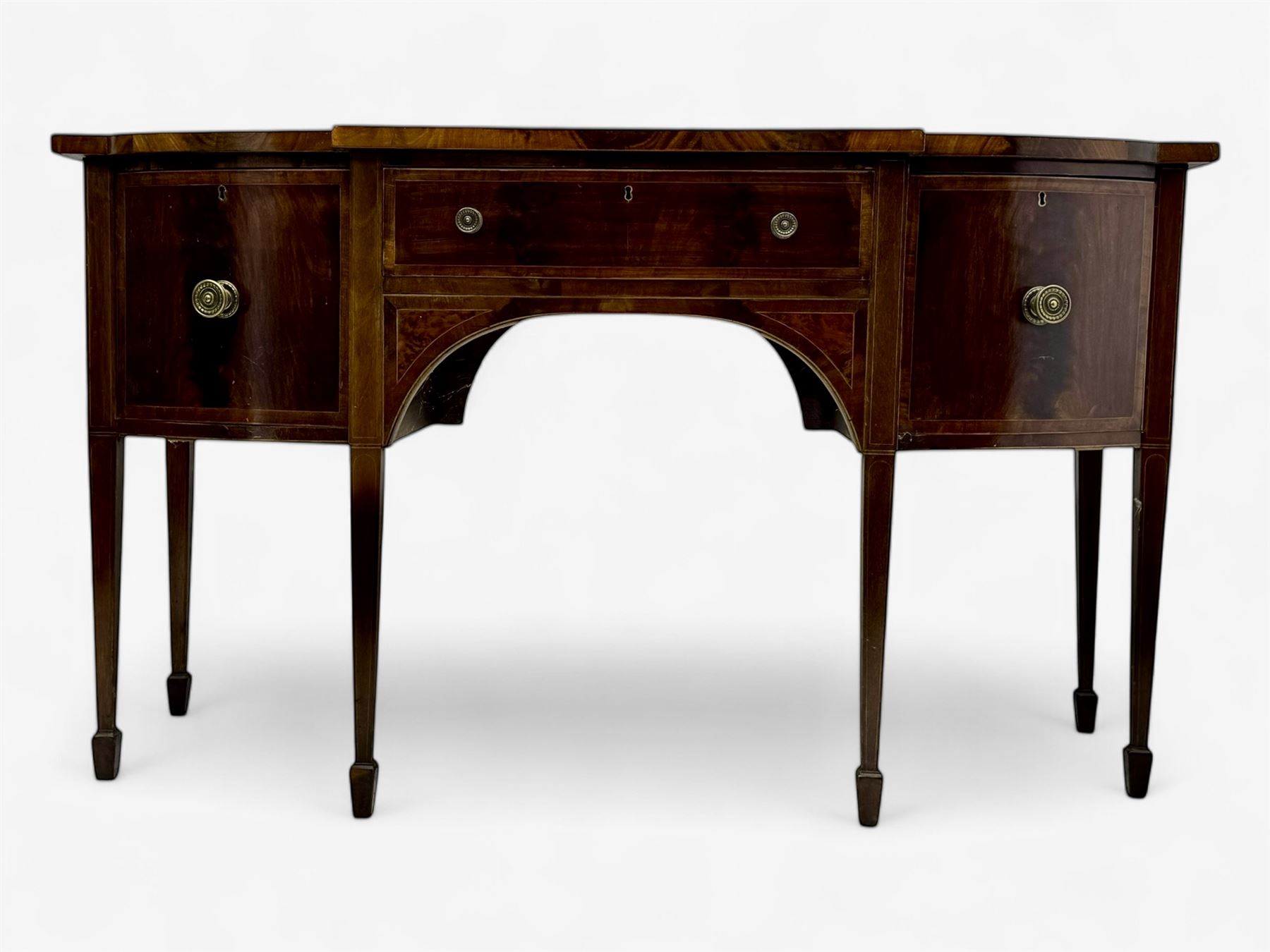 George III mahogany bow-fronted sideboard, serpentine-shaped top with crossbanded and boxwood stringing, over a central drawer flanked by deep cupboards, on square tapering supports terminating in spade feet