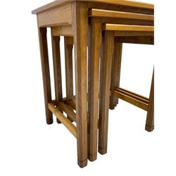 Acornman - oak nest of three tables, each with rectangular adzed tops and on chamfered supports, carved with acorn signature, by Alan Grainger, Brandsby, York
