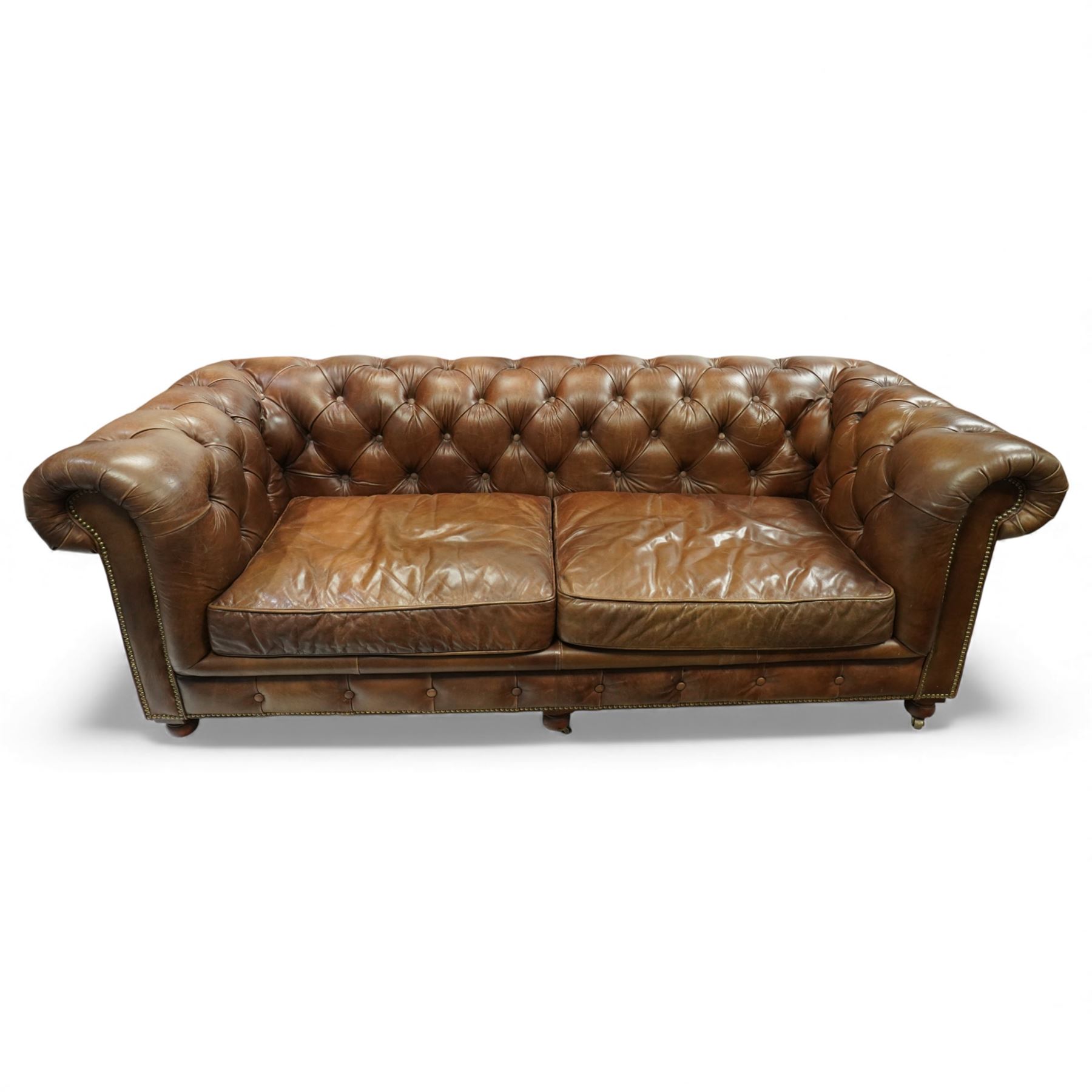 Timothy Oulton for Halo – tan leather three-seater Chesterfield sofa, fully deep-buttoned to the arms, back and seat, with studded front rail, rolled armrests and turned bun supports