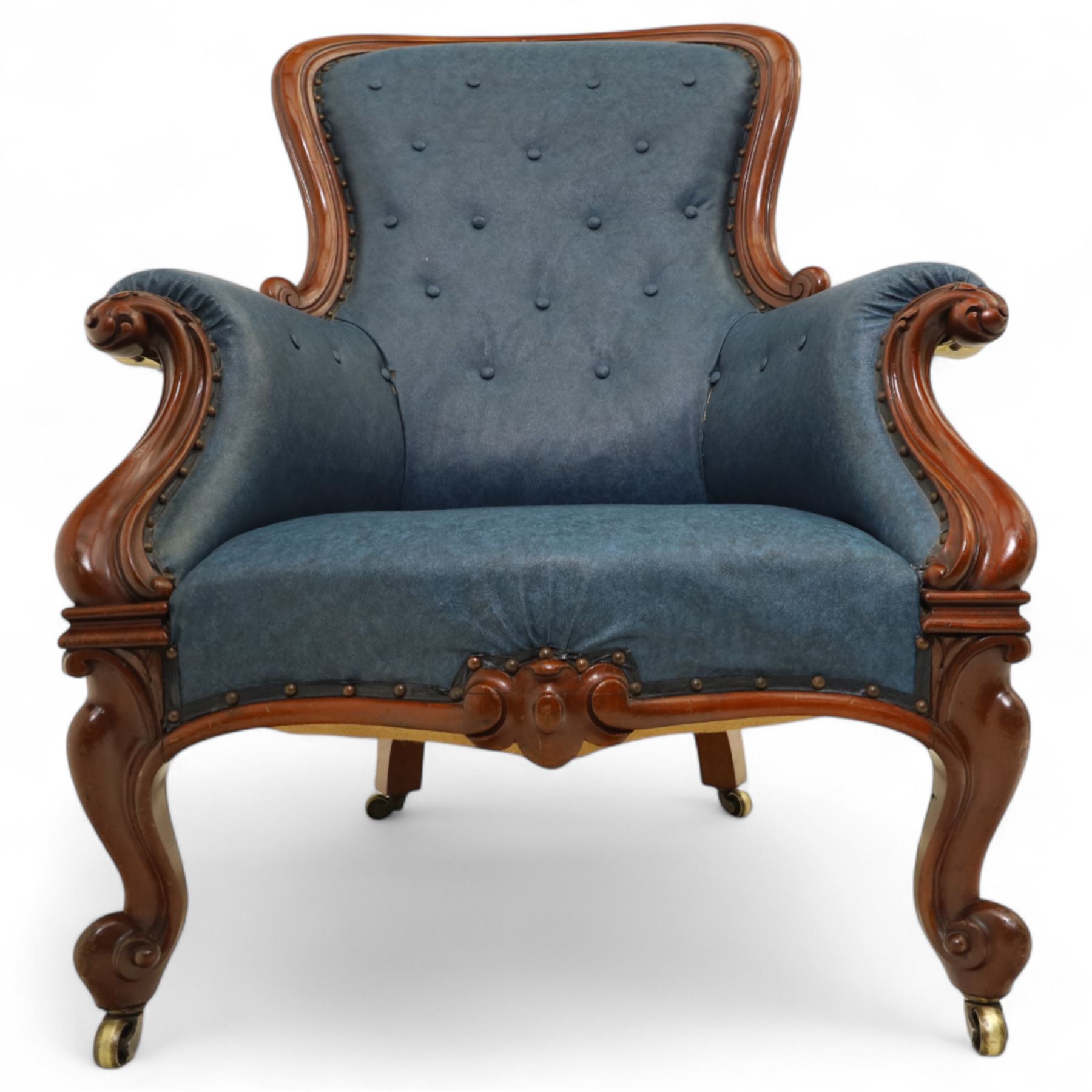 Fine pair of mid-19th-century mahogany library armchairs, carved frame with balloon-shaped back with scrolled ends, rolled wide arms, ending in a scrolled volute above a serpentine seat rail, upholstered in mottled turquoise faux leather, button upholstered back, arms, and cushion seat, studded sides and apron, raised on scroll carved front feet and splayed rear legs on castors 