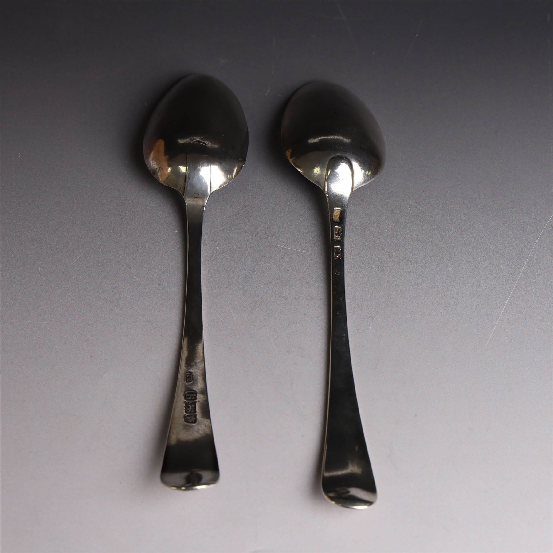 George II silver Old English pattern table spoon, with engraved initial W to terminal, hallmarked Thomas Northcote, London, probably 1758 date mark worn, together with a George III Old English pattern table spoon with bright cut decoration and engraved initials, hallmarked London 1783, makers mark TE probably for Thomas Evans
