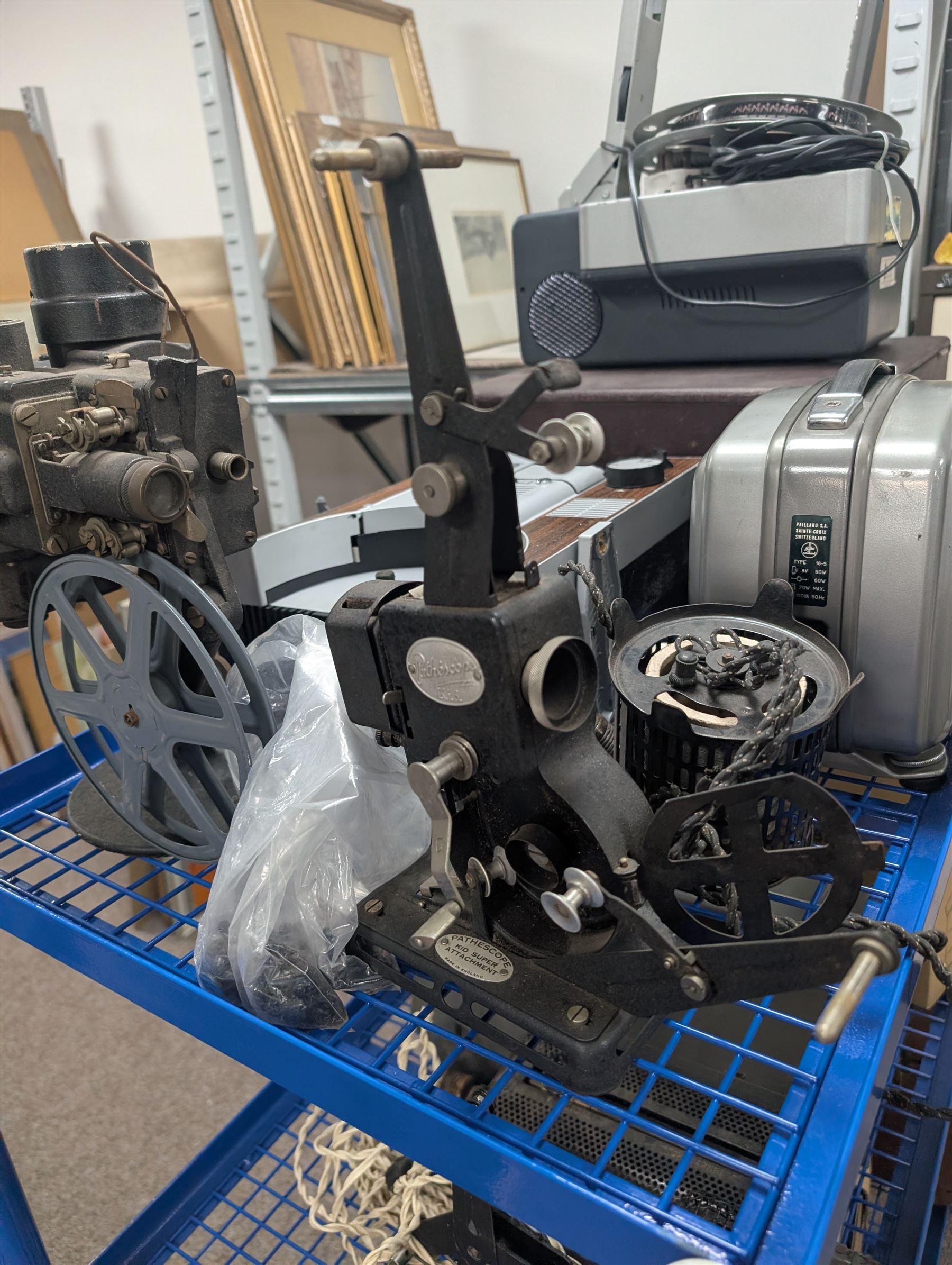 Collection of projectors, including Transpaque Junior overhead projector, Demo Comm 1 overhead projector, Bolex 18-9 Duo, Bolex 18-5, Pathescope Kid, Kodascope Model C, collection of video tapes and film reels, empty projector box, Kinay 816 editor, etc