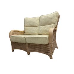 Contemporary rattan conservatory suite - two seat sofa with wicker frame and loose cushions upholstered in textured champagne fabric (W125cm H98cm); pair of matching armchairs (W72cm H98cm); rectangular glass-topped coffee table with rattan frame and undertier (W85cm D60cm H47cm); and matching square side table (W53cm H55cm)