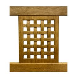 Mouseman - oak carver elbow chair, pierced and carved lattice back over leather upholstered seat with stud band, on octagonal supports united by plain stretchers, carved with mouse signature, by the workshop of Robert Thompson, Kilburn 