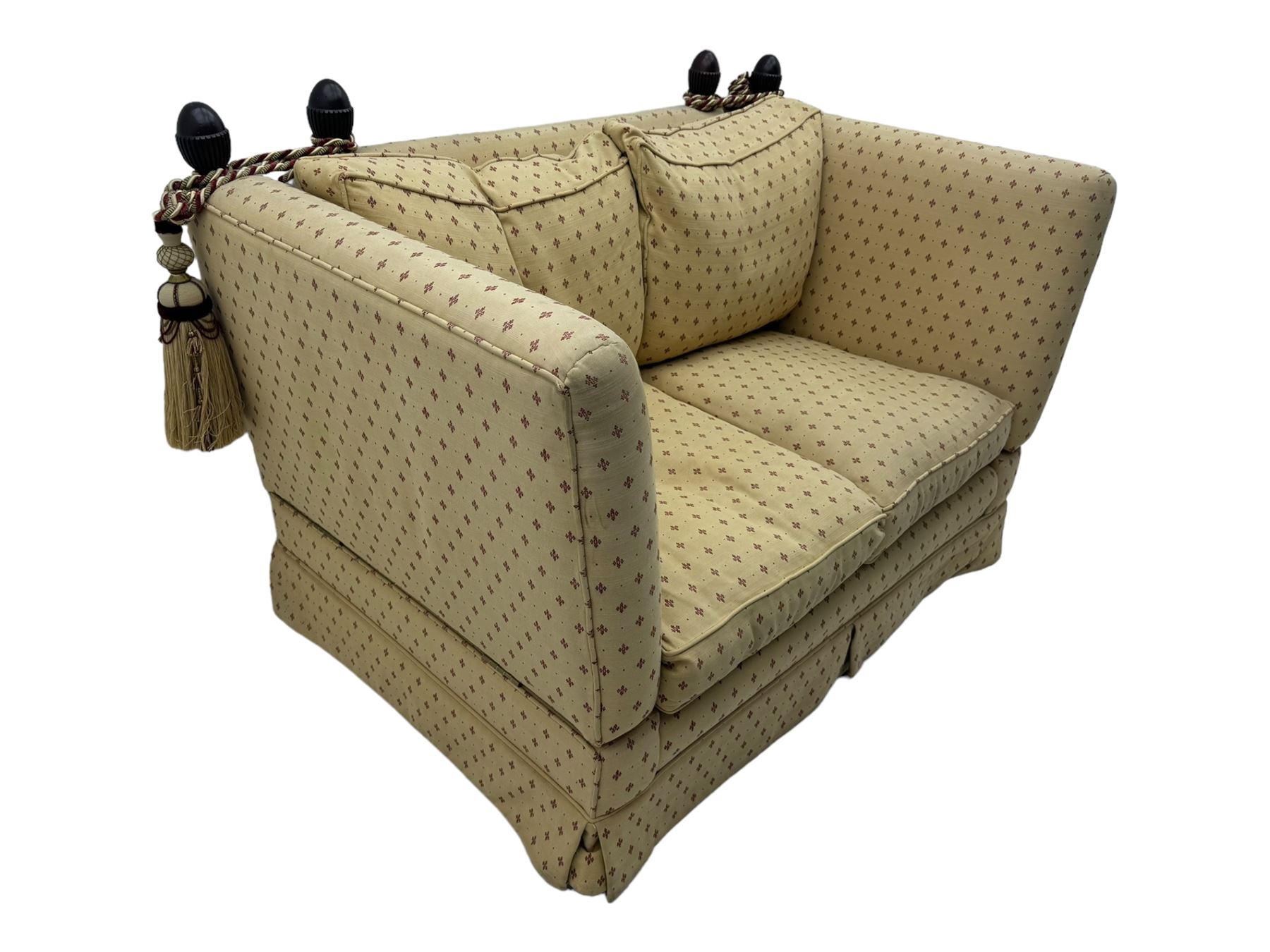 20th century Knole design two seat sofa, high back and double drop-arm joined by mahogany finials and ties, upholstered in camel ground fabric with red lozenge design, on turned supports with brass castors