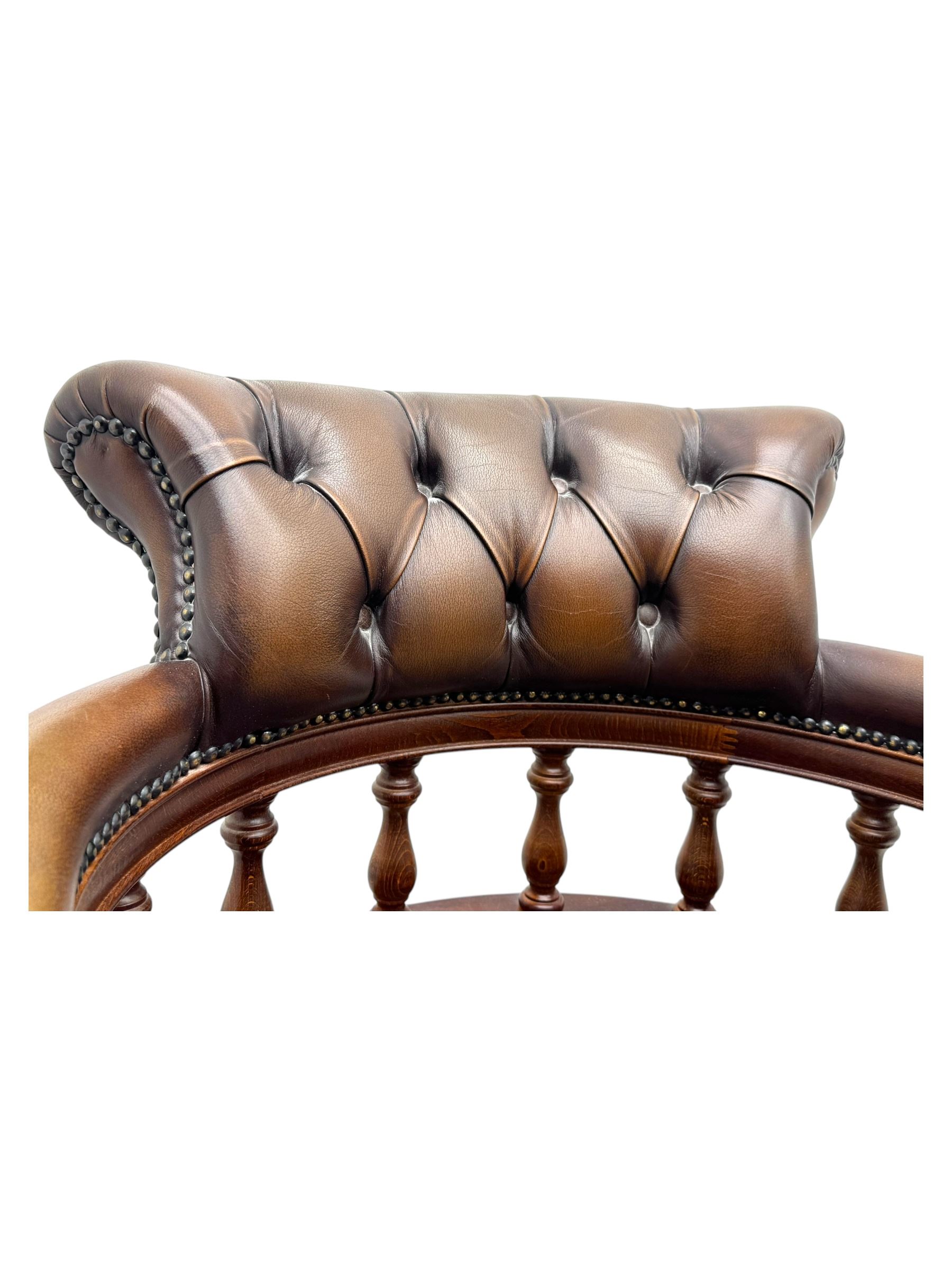 Mahogany framed swivel Captains desk chair, upholstered in brown buttoned leather, turned supports and swivel base on castors