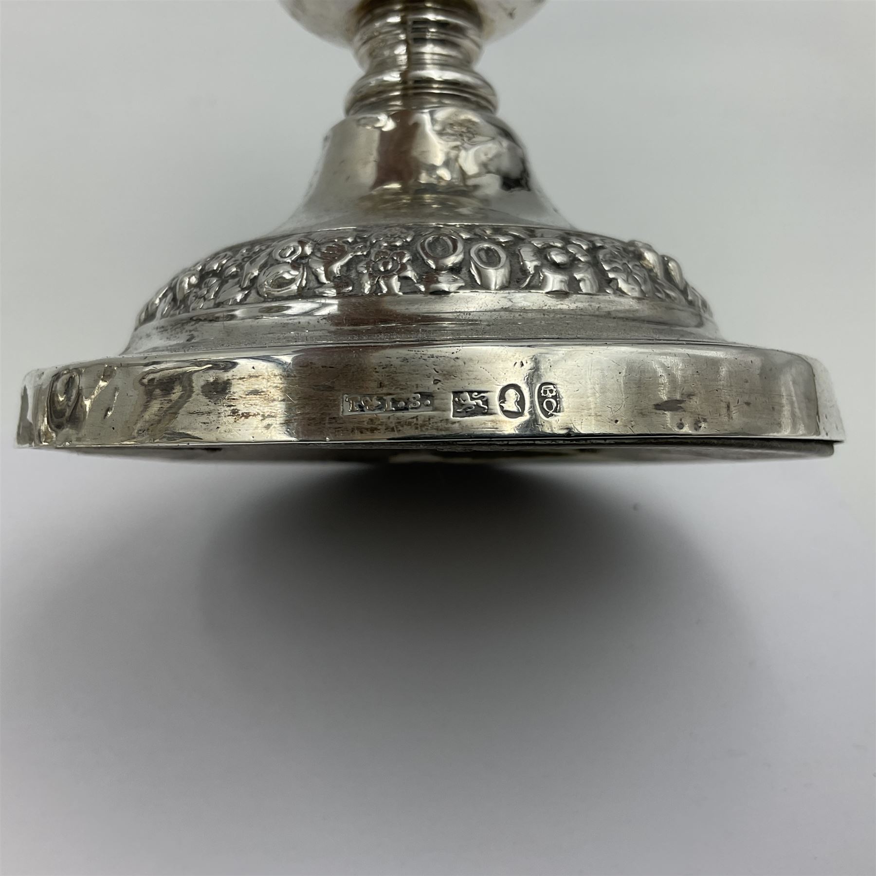 Four George III silver candlesticks, each upon knopped stem and weighted circular stepped foot, the foot and removable sconce repousse decorated with a band of flower heads, hallmarked to sconce and foot Thomas & John Settle, Sheffield 1820, H17.5cm