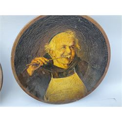 Two oil painted chargers decorated with joyful gentleman, both signed W Stanley, together with a Musterschutz charger decorated in high relief