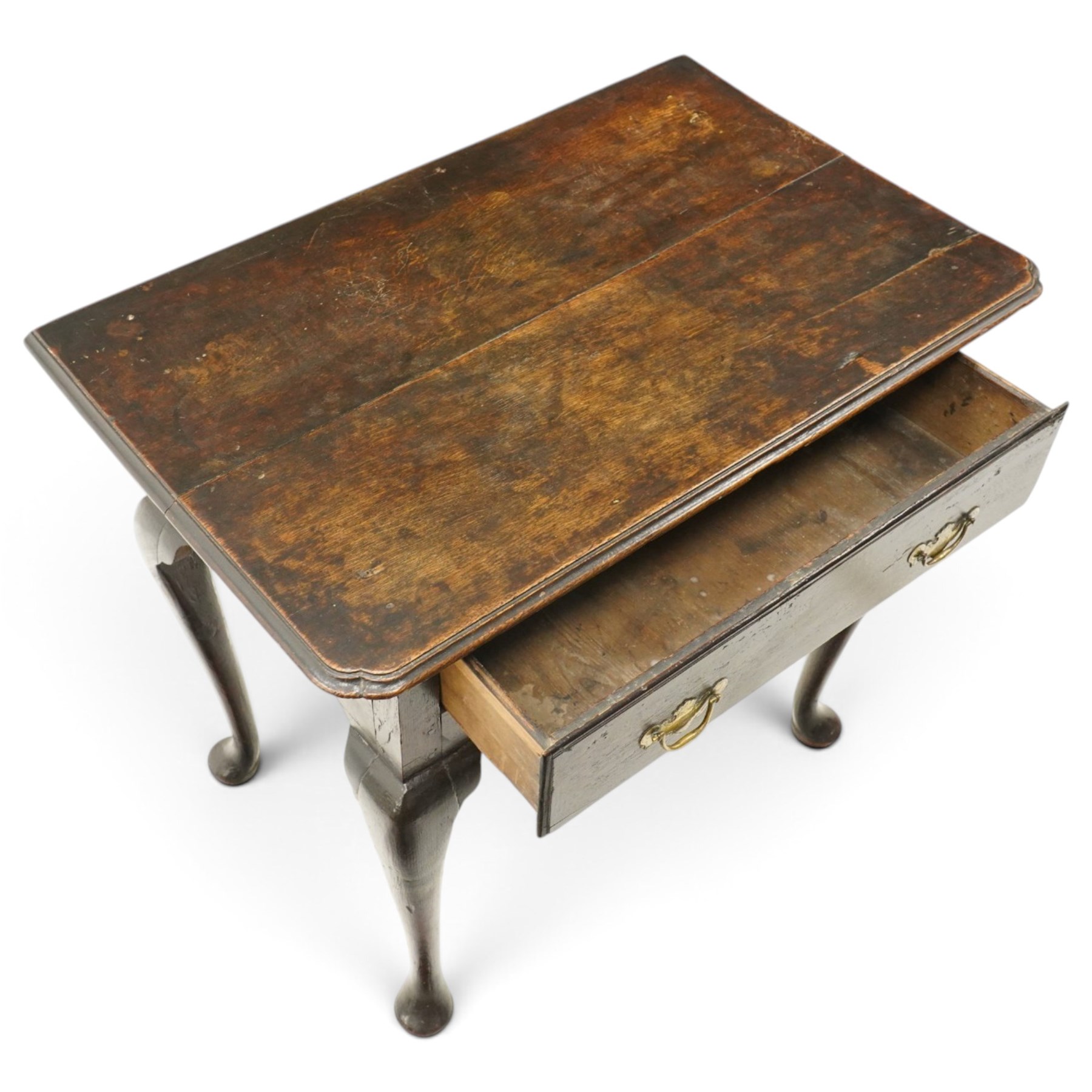 18th century oak lowboy, the rectangular top with moulded edge and eared front-corners, fitted with single drawer with pressed brass handle-plates, shaped apron over cabriole supports and pad feet