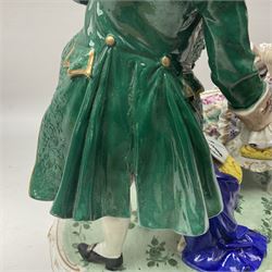 20th century Naples figure group, modelled as a seated female figure playing the lute seated, before a male figure stood holding a sheet of music, each in period dress, upon an oval base with gilt heightened scroll edge, with crowned N mark beneath, H31.5cm L33cm
