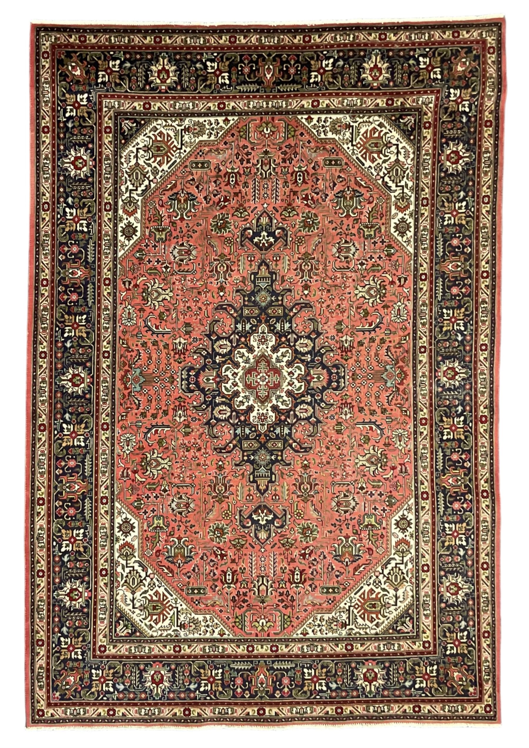 North West Persian pink ground Tabriz carpet, central indigo ground medallion surrounded by stylised plant motifs and trailing foliage, the main border with overall floral design within guard stripes 