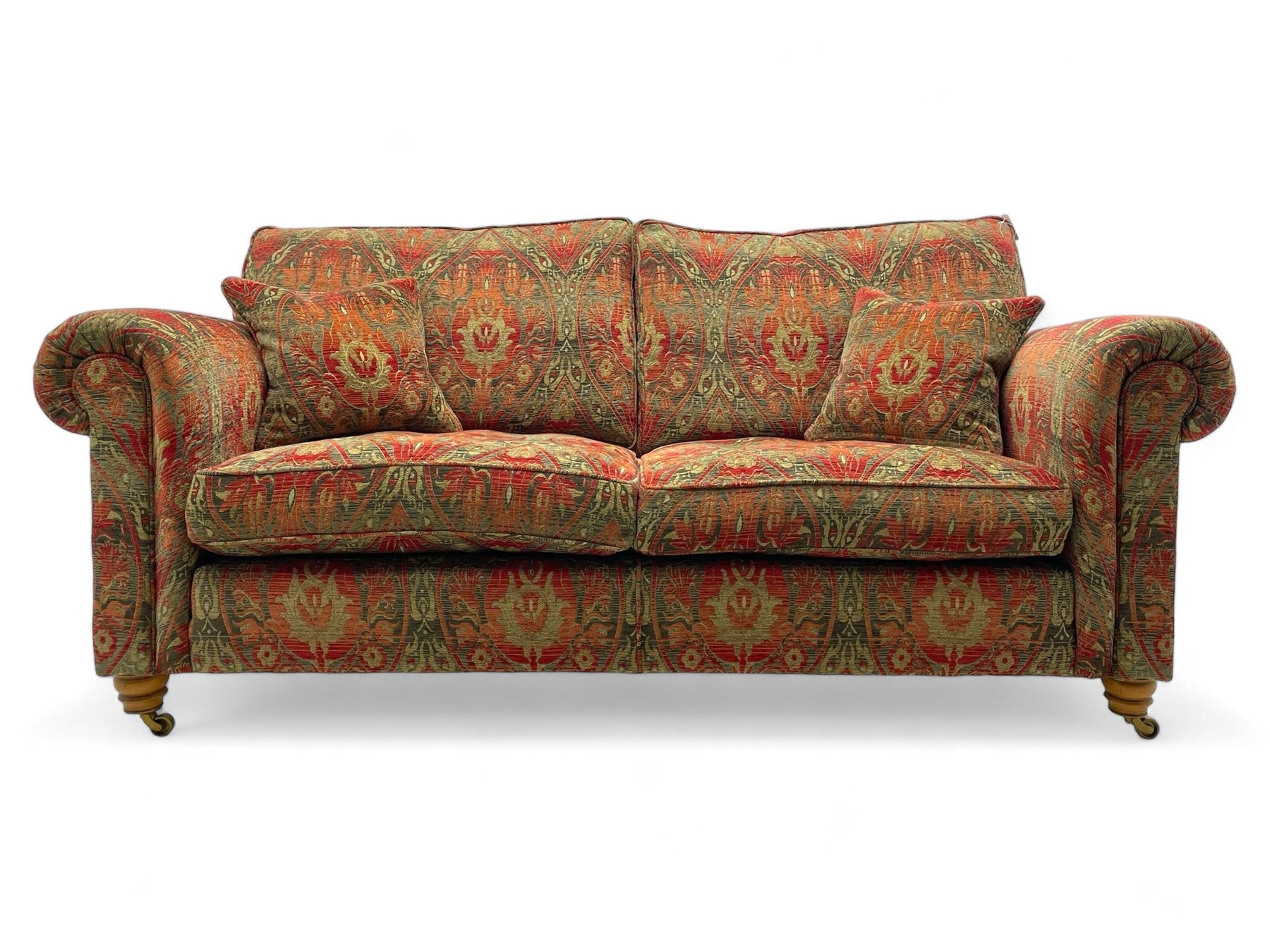 Duresta - 'Beaminster' grande two-seat sofa, traditional shape with rolled arms, upholstered in 'Althorp' russet and stone floral pattern fabric, on turned feet with brass castors
