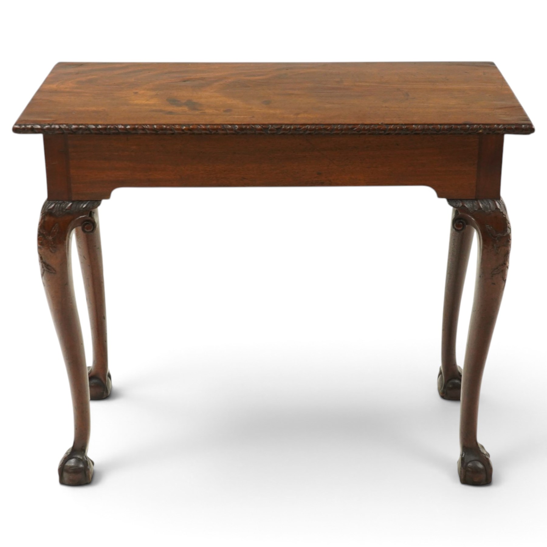 George I carved mahogany side table, adapted from a card table, the rectangular top with foliate-carved edge above a plain frieze, raised on cabriole legs with acanthus-carved knees, volute brackets and floral-carved motifs, terminating to ball-and-claw feet