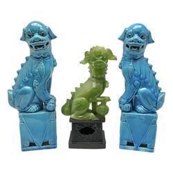20th century pair of blue glazed Foo Dog statues raised upon a square plinths, together with a similar green resin foo dog