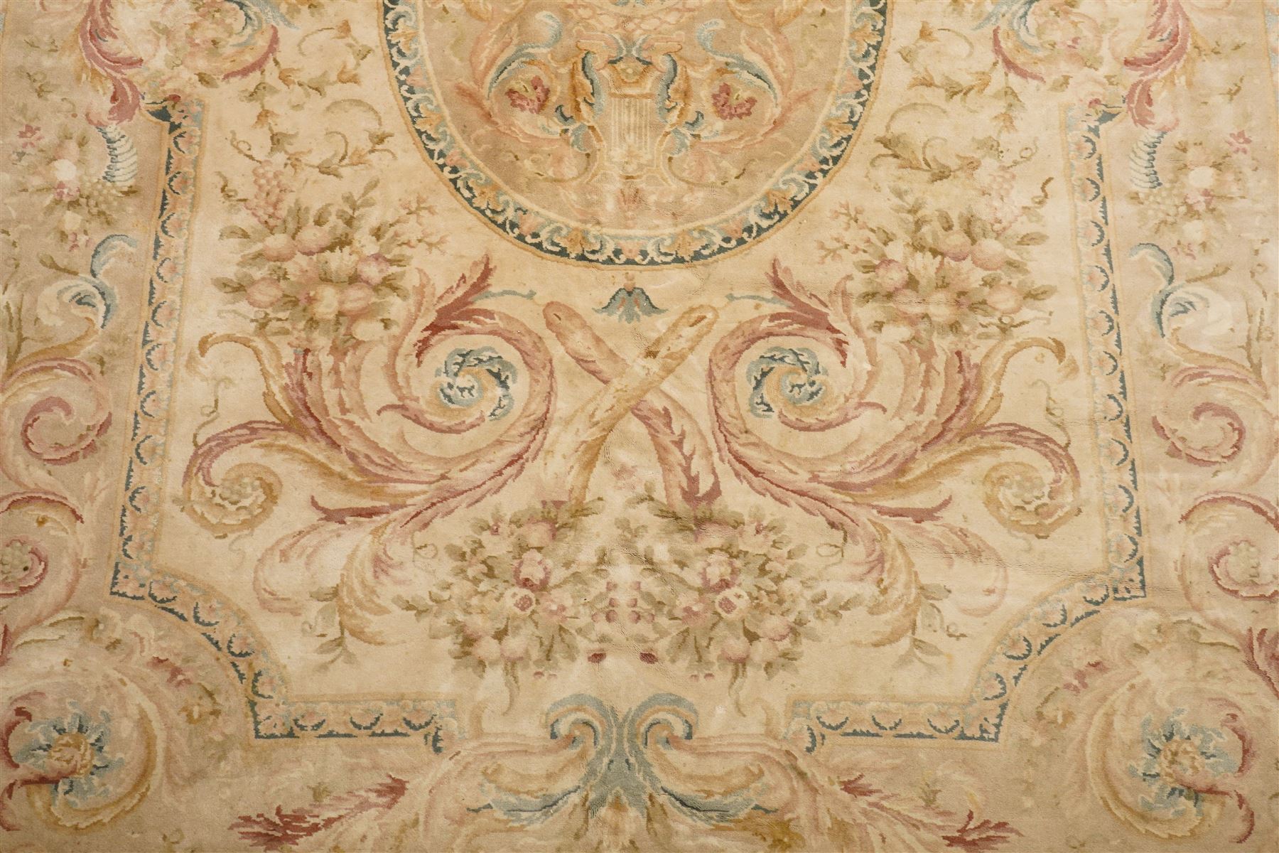 Large Aubusson design flatweave carpet, cream ground centred by oval medallion decorated with scrolling acanthus leaves and flowerheads, surrounded by floral sprays, foliate scrolls and rocaille motifs in muted pink, blue and gold tones, enclosed by conforming foliate border
