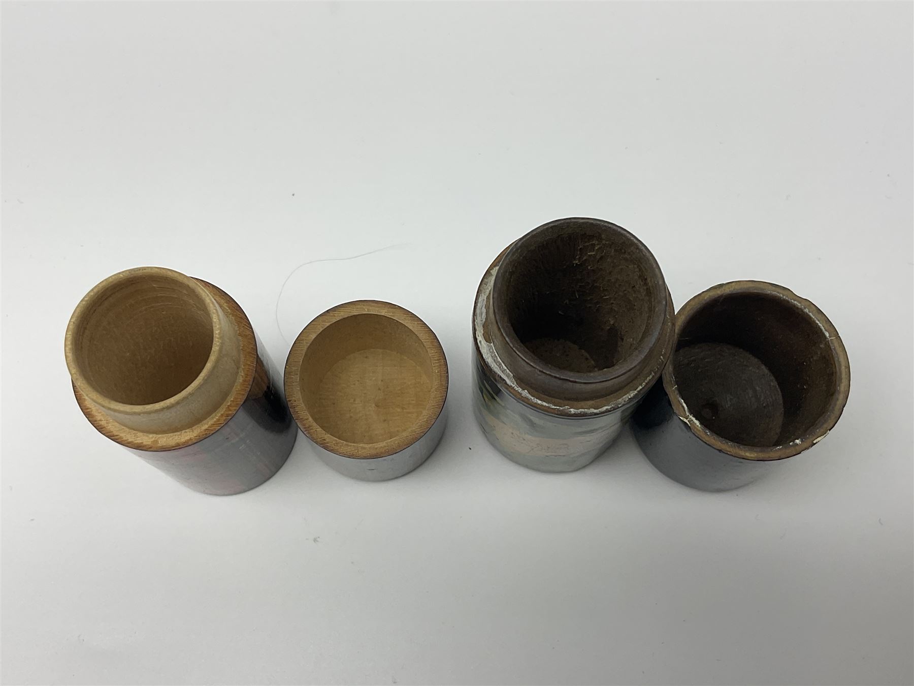 Mauchline ware black lacquered octagonal bobbin box, the hinged cover with forget-me-not floral decoration and sentimental verse, opening to reveal six bobbin holders and retail label for Clark & Co, together with a Mauchline ware sewing box, with floral decoration throughout and verse to hinged cover, a similar black lacquered needle holder and a Mauchline Tartan ware needle holder, largest diameter D11.5cm