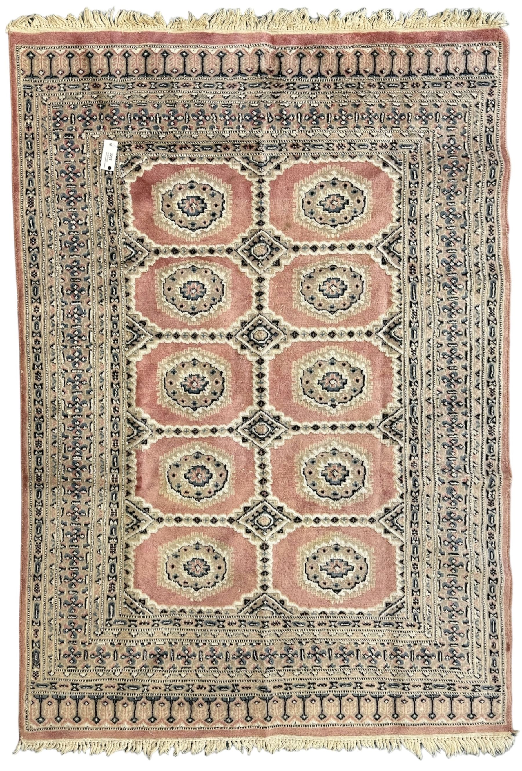 Persian design pale pink ground rug, the field divided into panels and decorated with Gul motifs, wide multi-band border with geometric patterns 