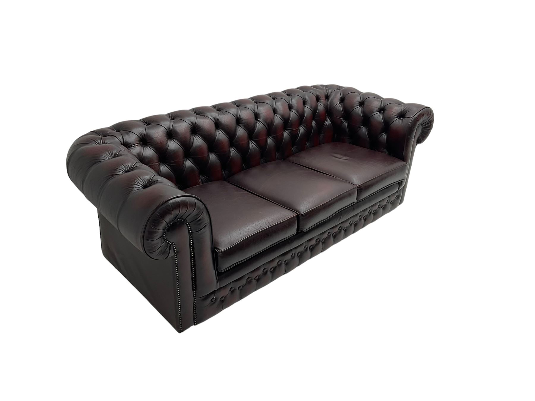 Thomas Lloyd - three seat Chesterfield sofa, upholstered in buttoned oxblood leather, on castors 