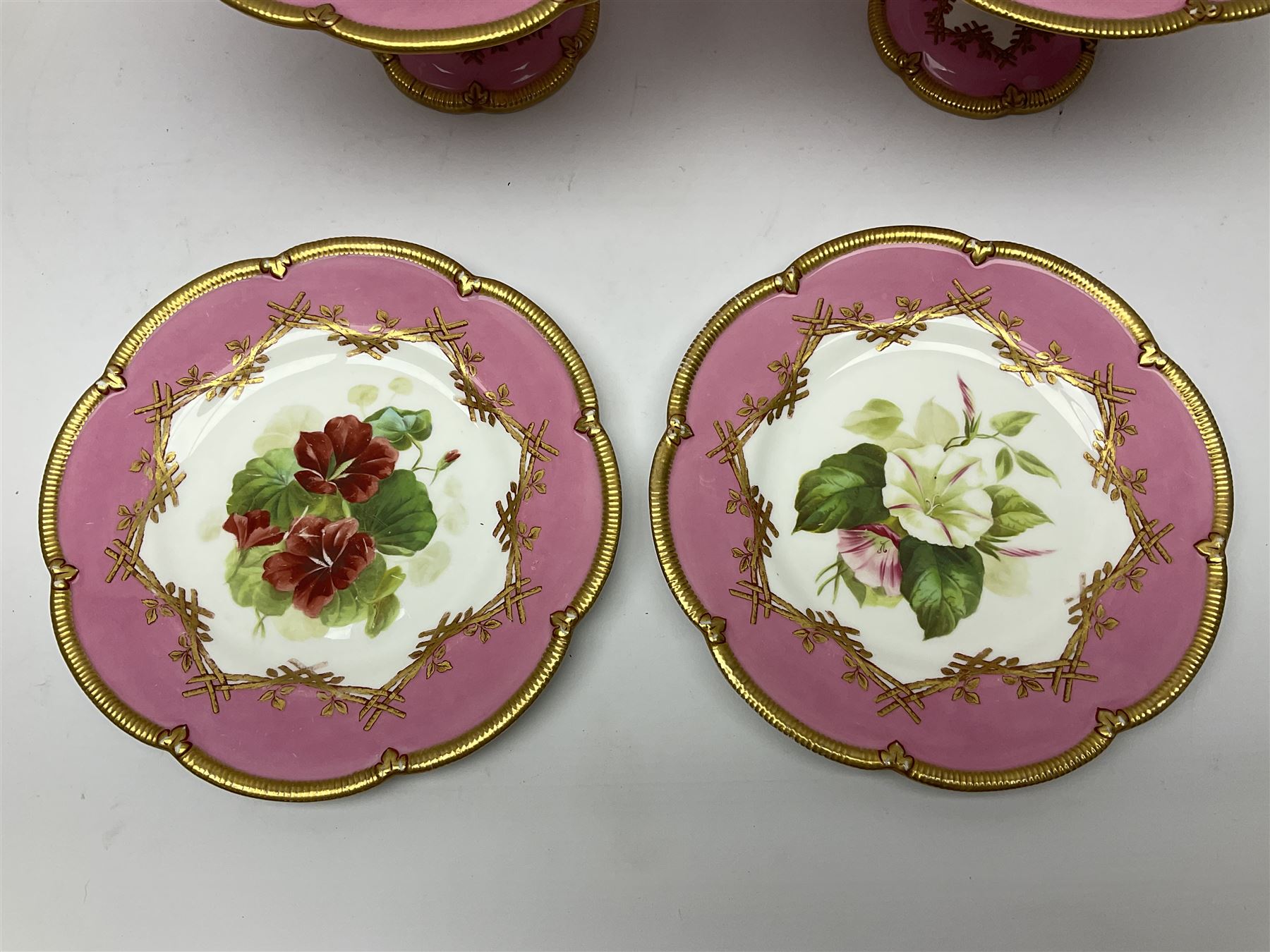 Victorian dessert service, comprising four comports and nine plates, each decorated with floral sprigs to the centre with a pink and gilt border, largest comport H13cm, plate D22.5cm