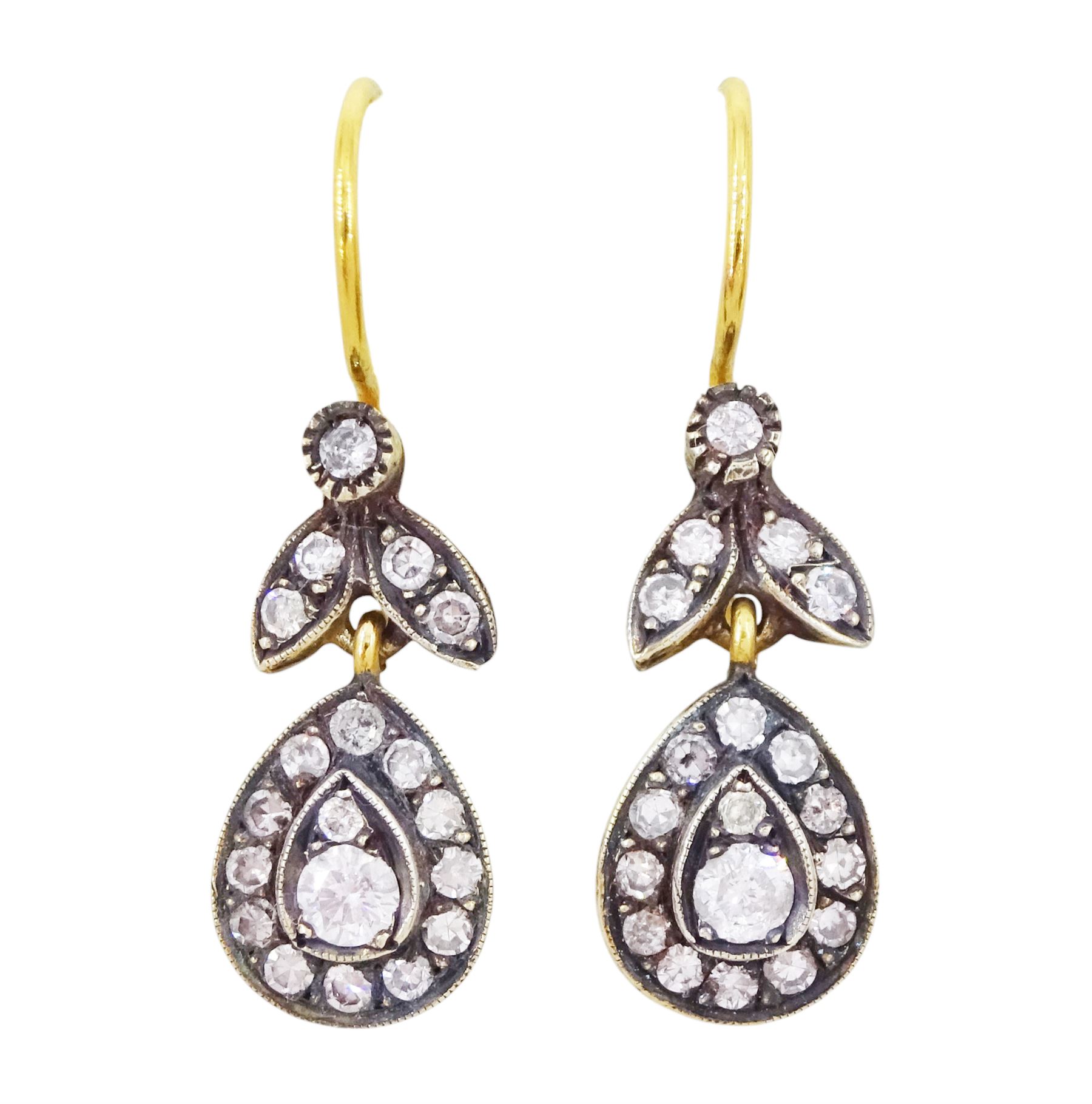 Pair of gold and silver diamond earrings, each pendant with pear shaped drop set with round brilliant cut and single cut diamonds, suspended from a diamond set leaf design bail, total diamond weight approx 1.00 carat