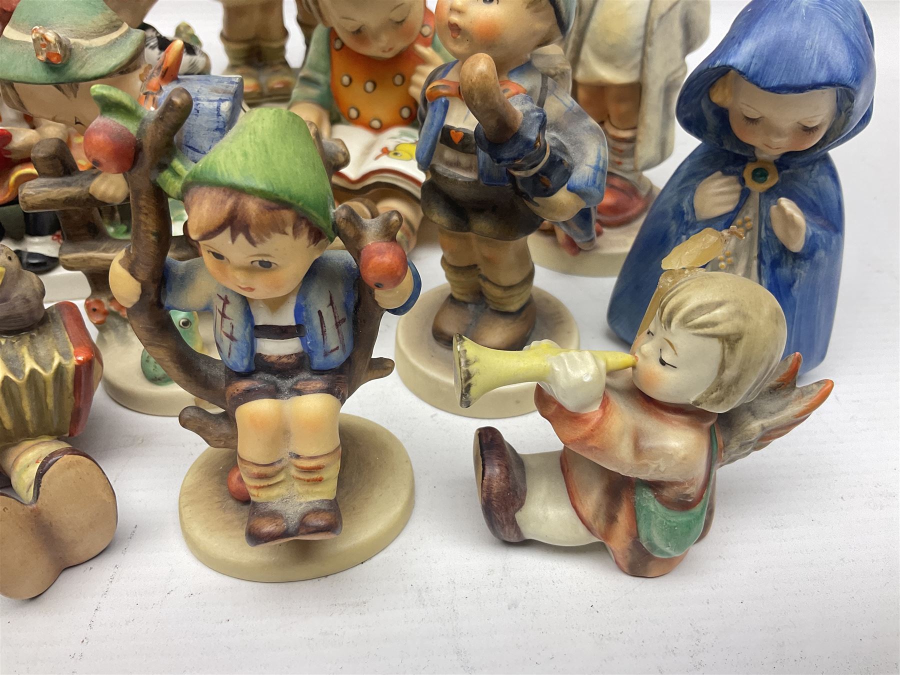 Sixteen Goebel Hummel figures, including Charlot A Young Man's Fancy, Stormy Weather and Bookworm, all with impressed and printed marks beneath