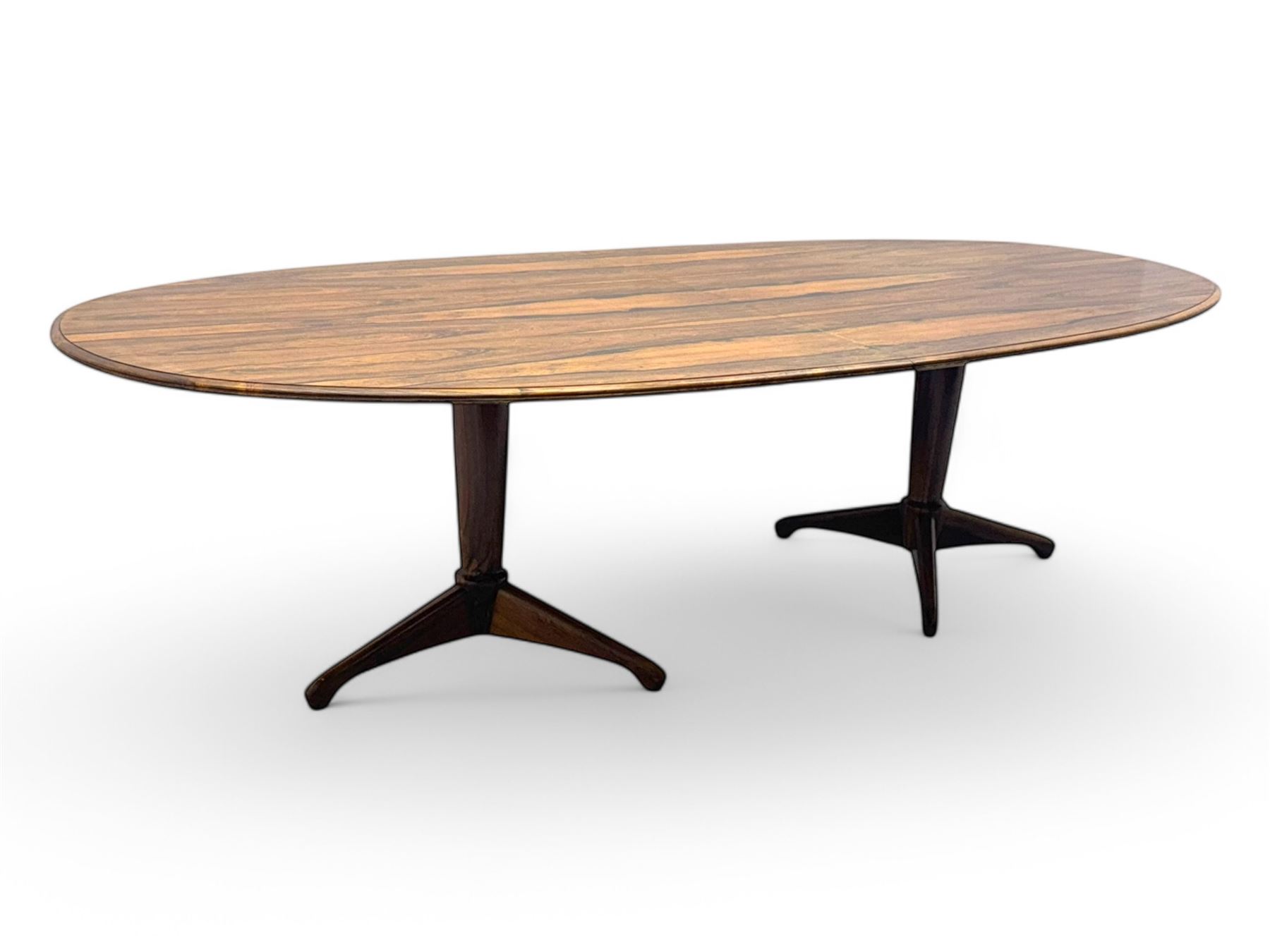 Andrew Milne for Heals - mid-20th century extending dining or boardroom table, oval top with one additional leaf, raised on twin tapering pedestal supports terminating in tripod feet