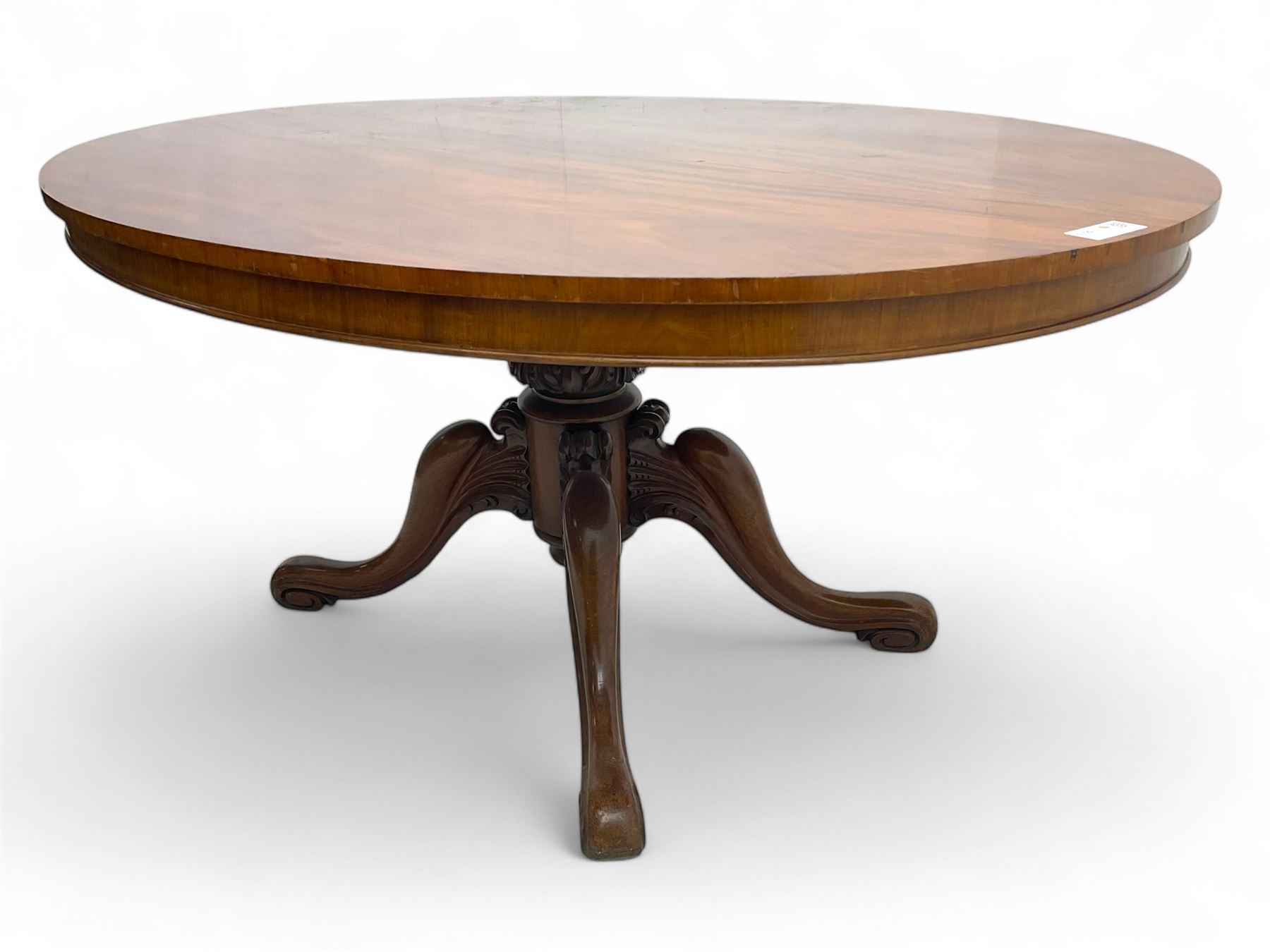 Victorian mahogany breakfast loo table, oval tilt-top on turned pedestal, quatrefoil out-splayed carved supports, scroll carved terminals with brass castors