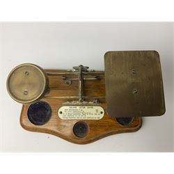 Brass postage scales on shaped moulded mahogany base, bearing ivorine central label 