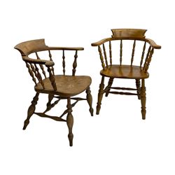 Late 19th century elm smoker’s bow armchair, curved top rails over turned spindle backs, shaped seats, raised on turned legs united by turned stretchers; together with a similar smoker’s bow armchair (2)