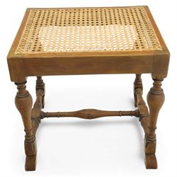 Two upholstered and caned footstools, a late Victorian carved mahogany footstool, oval form upholstered in geometric kilim-style fabric, on cabriole supports (H 27cm, W 56cm, D 47cm), together with a 20th century beech stool, square caned seat on turned supports united by stretchers (H 43cm, W 44cm, D 37cm)