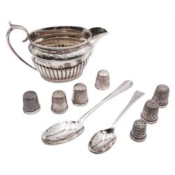 Group of silver, comprising Edwardian cream jug, of oval part fluted form, hallmarked Walker & Hall, Sheffield 1901, seven 20th century thimbles, to include a number of named examples, various hallmarks, five assayed Birmingham, Victorian teaspoon with rat tail bowl, hallmarked Brewis & Co, London 1895, and an early 20th century coffee spoon, approximate total weight 5.22 ozt (162.4 grams)