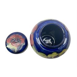 Moorcroft ginger jar, decorated in the Hibiscus pattern upon a blue ground, with paper label beneath detailed 'Potters to the late Queen Mary', H11cm.
