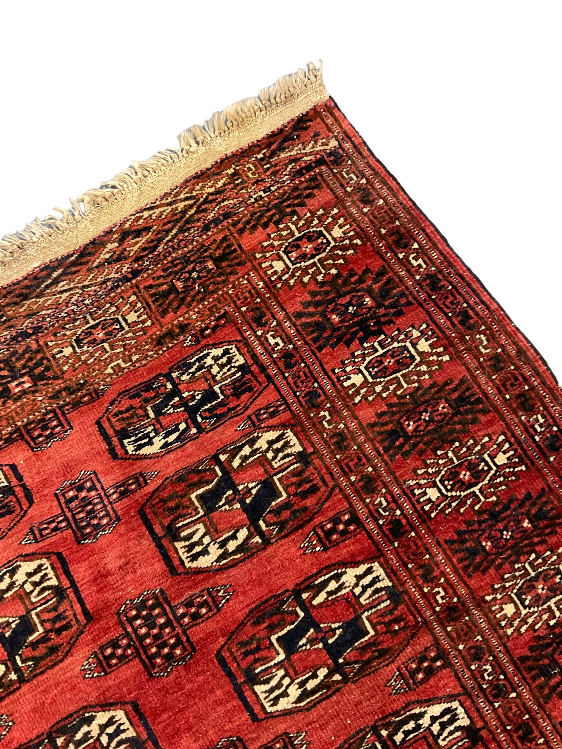 Bokhara red ground rug, decorated with two rows of Gul motifs, the border with geometric guard bands decorated with stylised plant motifs