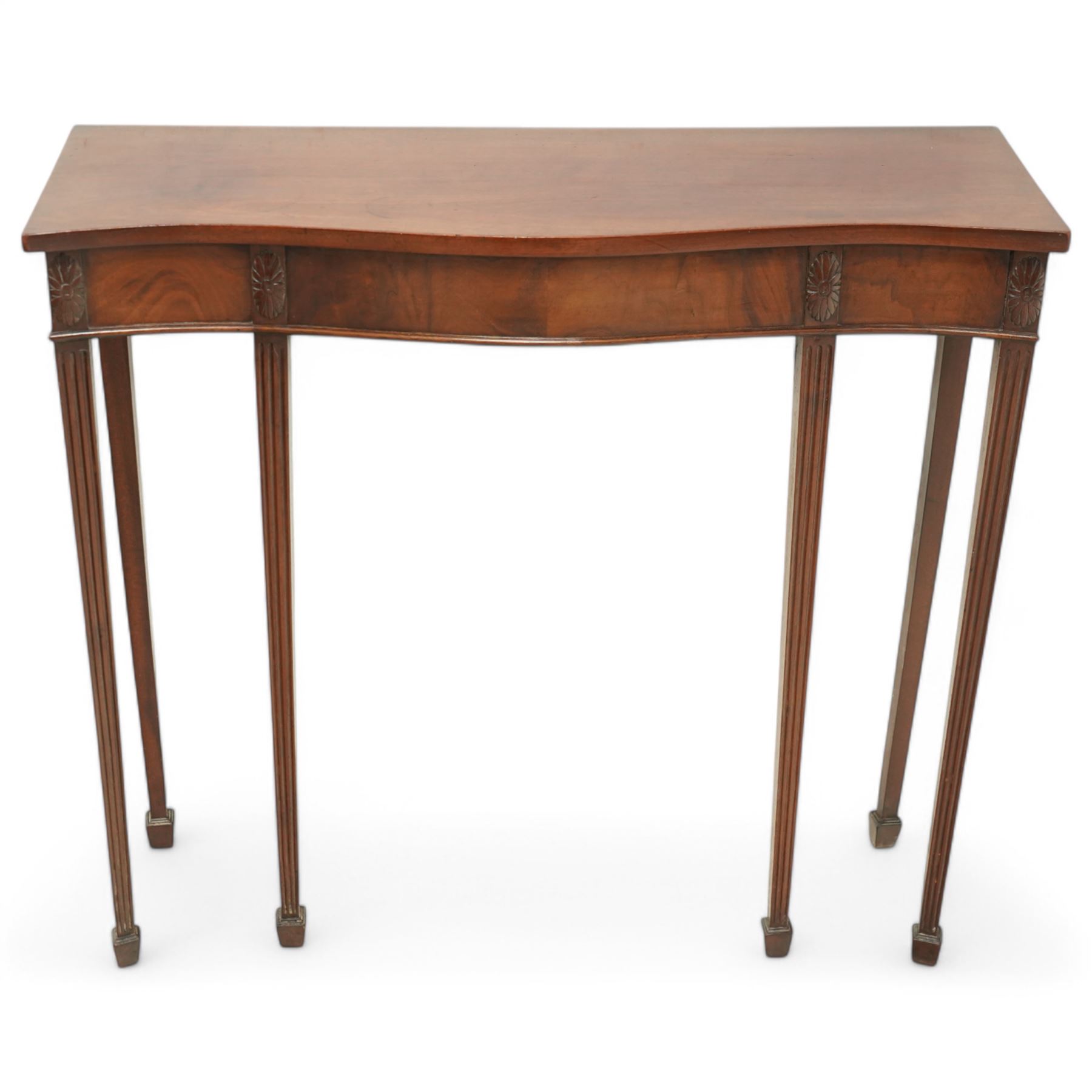 Edwardian mahogany serpentine side table or console table, figured frieze decorated with applied carvings, on six square tapering supports with spade feet