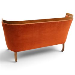 Edwardian inlaid mahogany tub two seater settee, traditional shape with satinwood stringing, upholstered in crimson fabric with sprung seat, on square tapering supports with castors