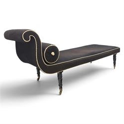 Victorian ebonised chaise longue, upholstered in black fabric with scroll headrest and bolster cushion, rectangular seat with rounded corners, raised on turned supports terminating in brass and ceramic castors