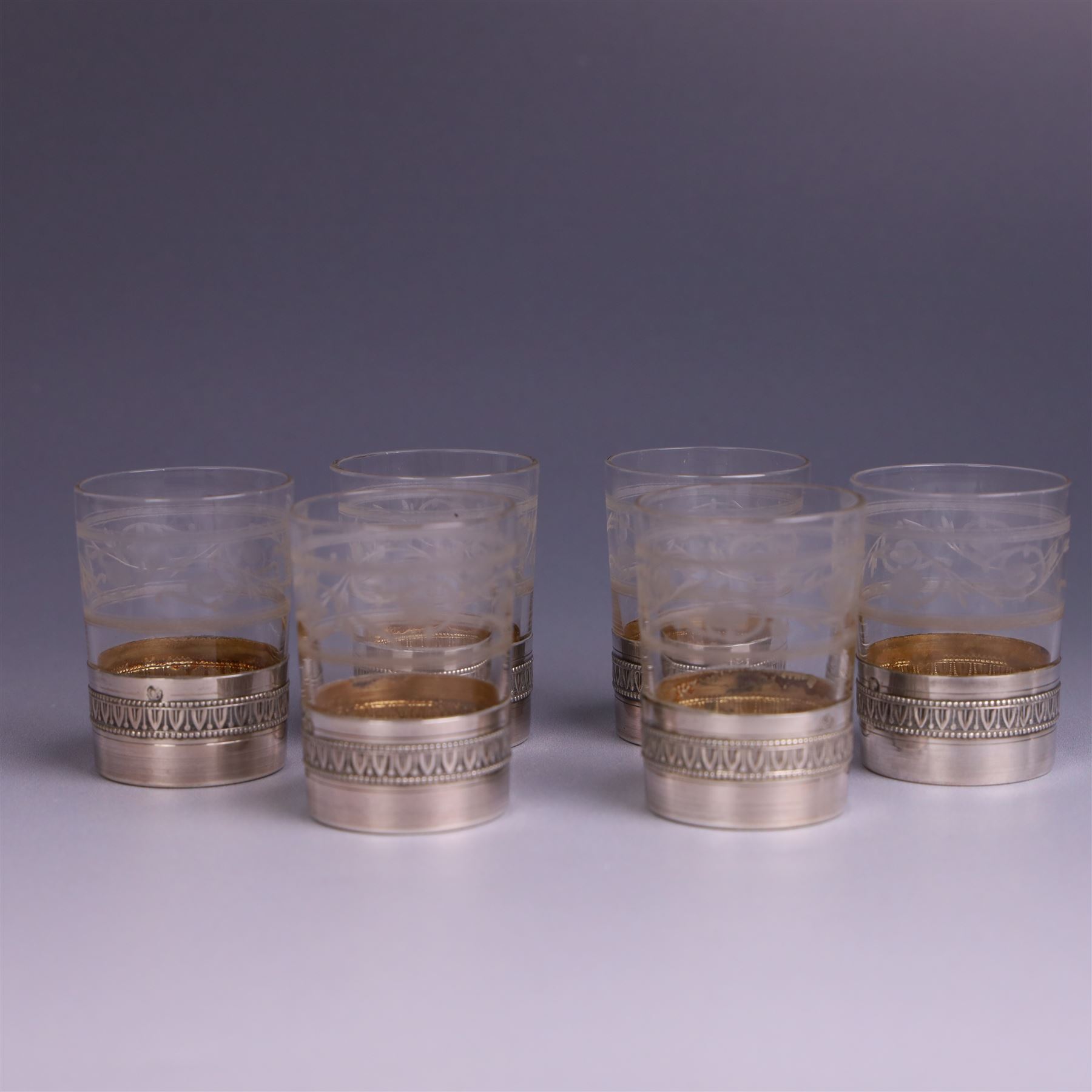 French silver mounted glass decanter and shot glass set, the decanter with silver covered stopper, removable silver collar, and etched decoration to glass body, the six silver mounted glasses each with etched decoration, silver stamped with Minerva's head, decanter H 21cm