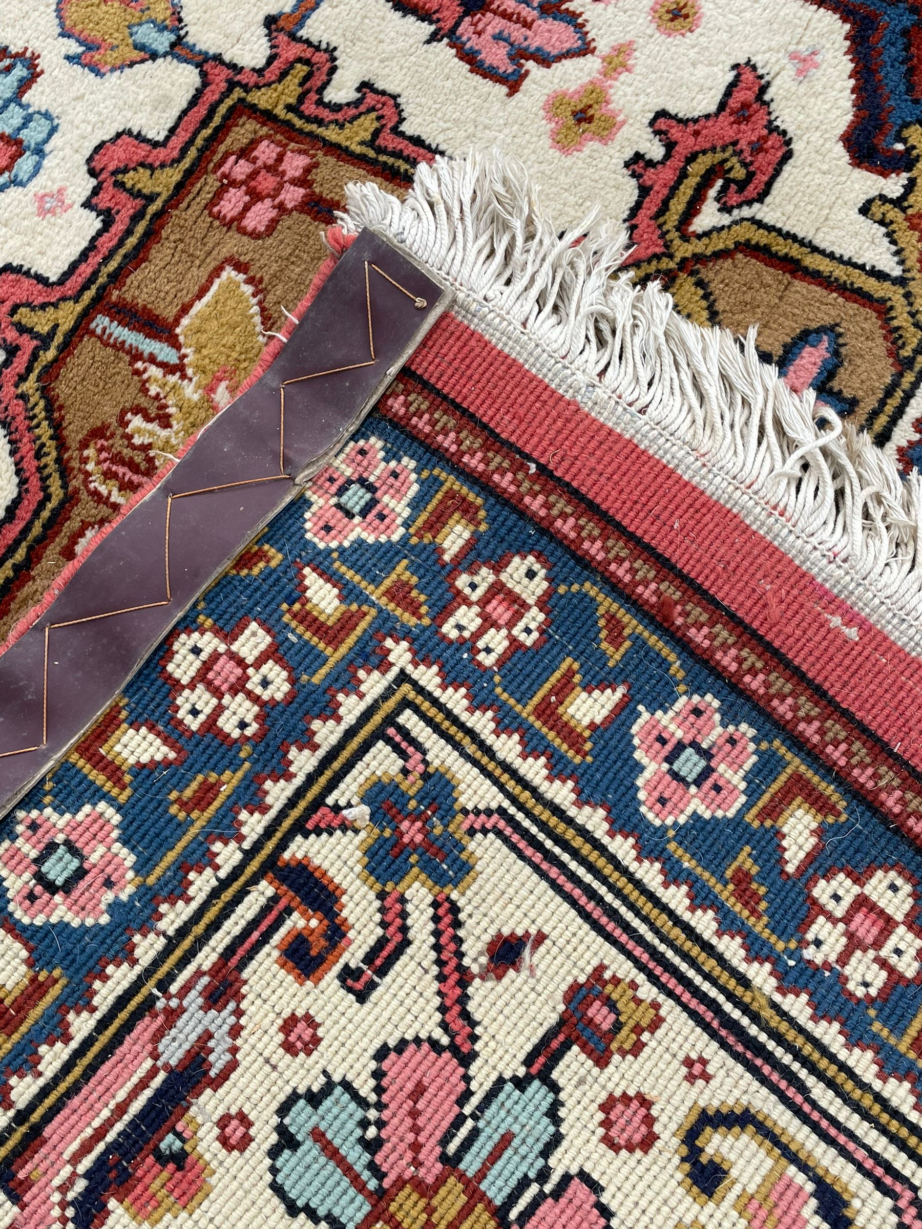 Large Persian carpet, the geometric and stylised floral medallion on rust ground field decorated with stylised plant motifs, guarded ivory border with repeating pattern