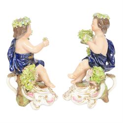 Pair of 19th century Stevenson and Hancock Derby figural chambersticks, each modelled as a seated cherub with arm around foliate encrusted sconce, marked beneath, H18cm