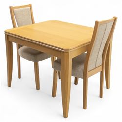 Ercol - light oak ‘Artisan’ rectangular dining table with chamfered top extending fold over top and tapered legs, together with two matching high back dining chairs upholstered in textured beige fabric (Chairs H 98cm, W 47cm, D 52cm)
